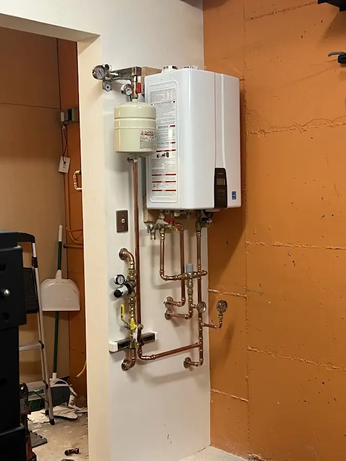 Plumbing technician inspecting water heater connections in Rockford